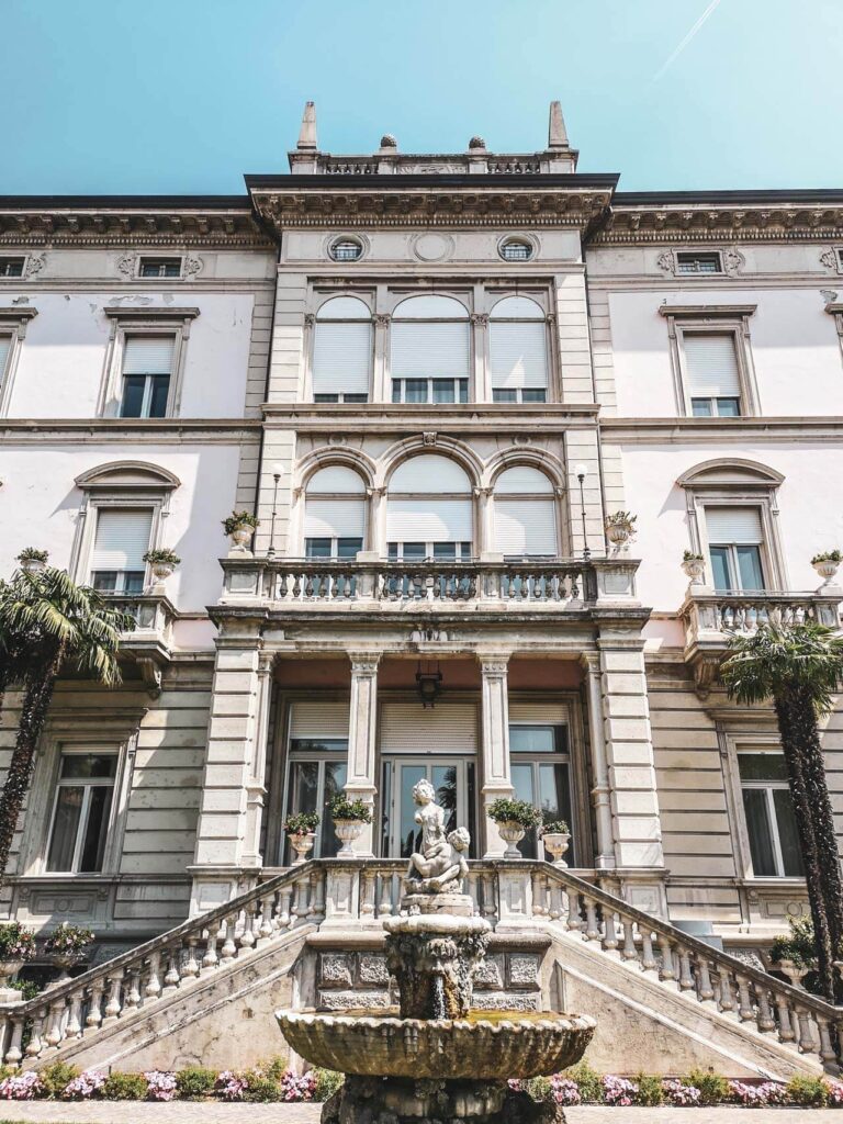 Riva del Garda am nördlichen Gardasee in Italien: Das Bild zeigt die Fassade des Grand Hotel Liberty in Riva del Garda mit einem Springbrunnen im Vordergrund