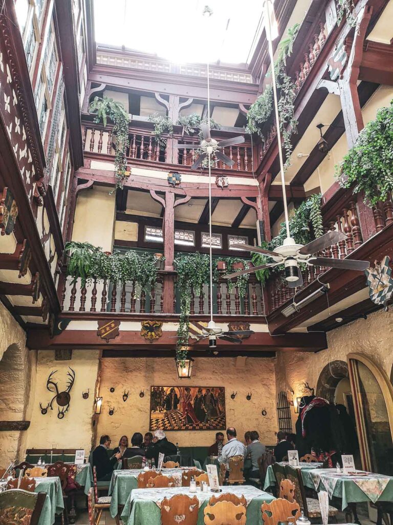 Das historische Baumeisterhaus in Rothenburg ob der Tauber mit Fachwerkgalerie und Pflanzen im Gastraum