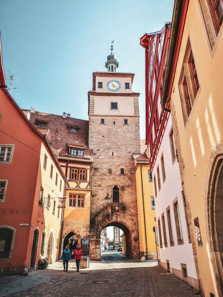 Das mittelalterliche Rothenburg ob der Tauber. Das Bild zeigt das Galgentor, umgeben von Fachwerkhäusern in Rot-, Gelb- und Orangetönen im Abendlicht
