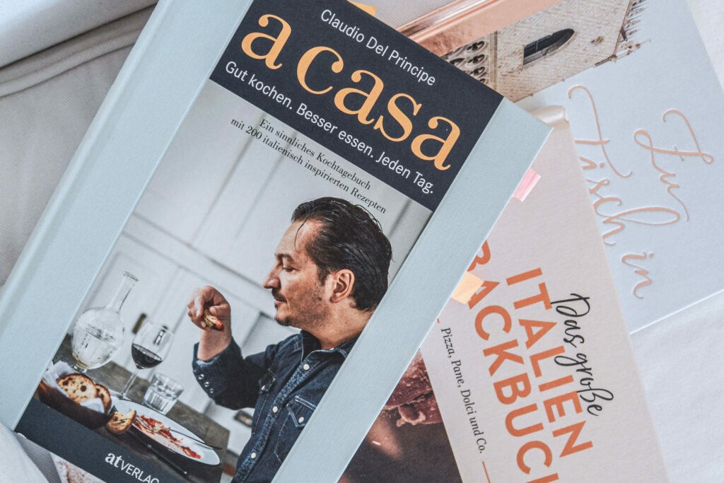 Italienfeeling für zu Hause: Kochbücher zum Thema italienische Küche und Italien auf einem Stapel zur Inspiration