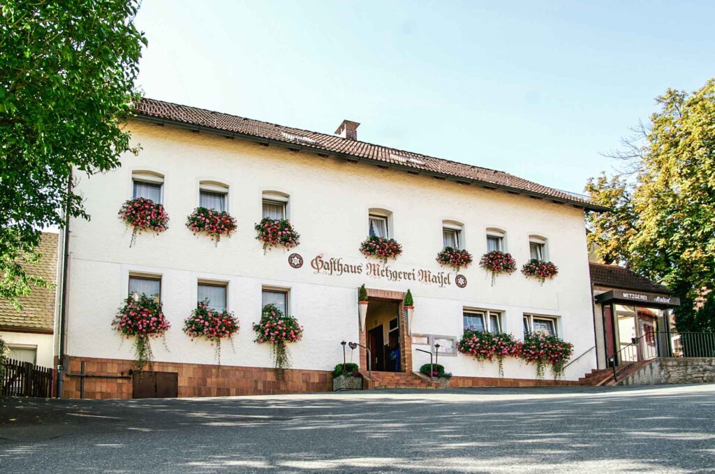 Sonntags im fränkischen Wirtshaus: Traditionelle Fassade der Gaststätte Maisel in Bayreuth mit roten Geranien als typisches fränkisches Detail