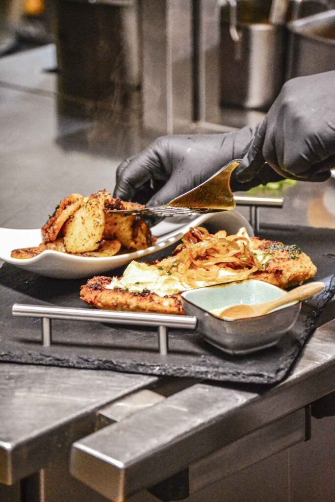 Sonntags im fränkischen Wirtshaus: Schnitzel „Auf der Alm“ wird in der Küche der Gaststätte Maisel in Bayreuth angerichtet