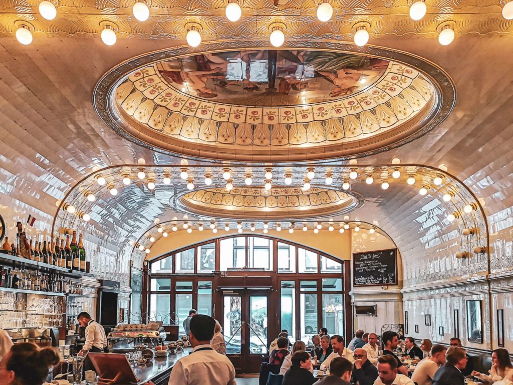 Frühstücken in Hamburg: Das Café Paris Hamburg mit Jugendstil-Kacheln und Ornamenten, die Szenen aus Hamburgs Handelsgeschichte zeigt