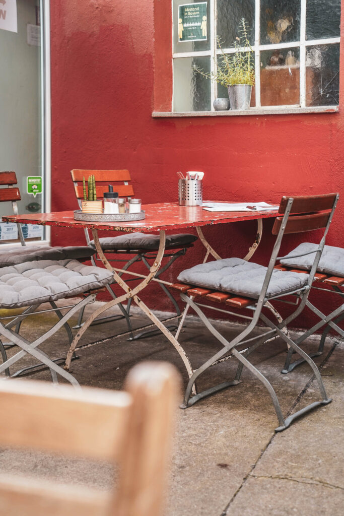 Tisch fuer vier Personen im Innenhof des Café Wunschlos gluecklich in Würzburg