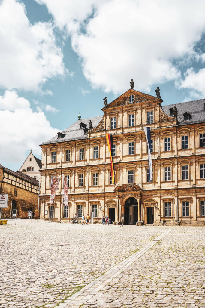 Die Residenz Bamberg auf dem Domplatz im Sommer bei blauem Himmel, davor Pflasterstein