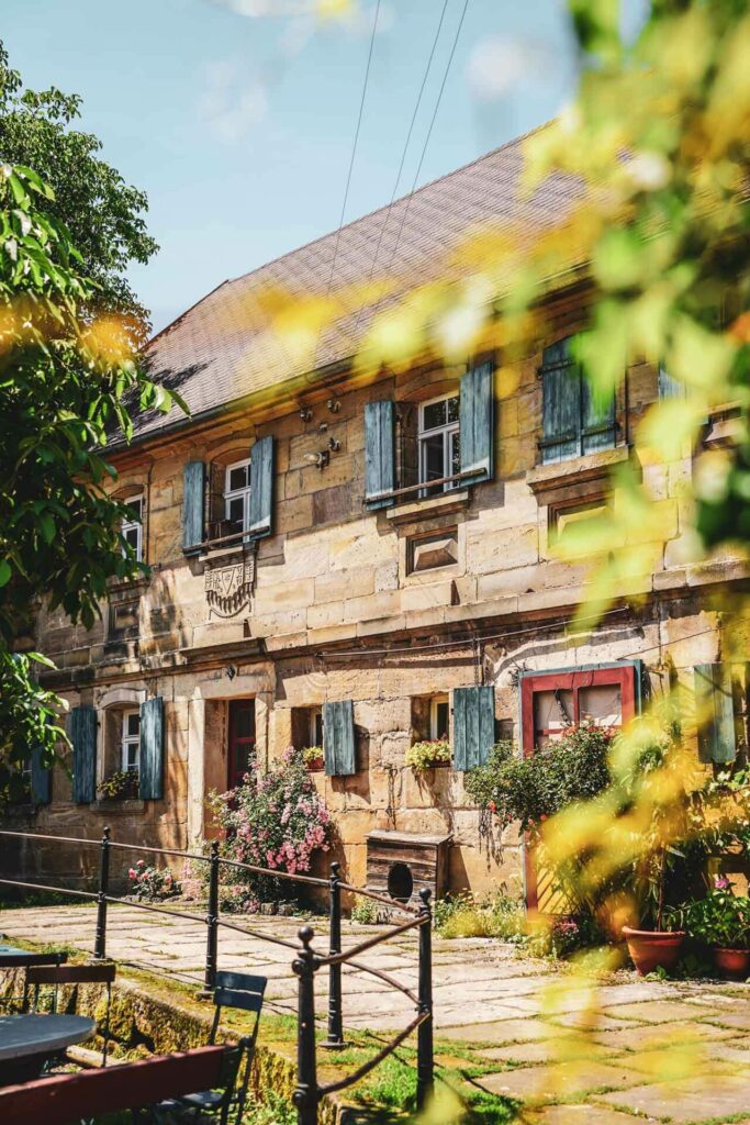 Restauranttipps für Bayreuth: Der Biergarten auf der Theta nahe Bayreuth: Ein alter Sandstein-Bauernhof mit blauen Fensterläden