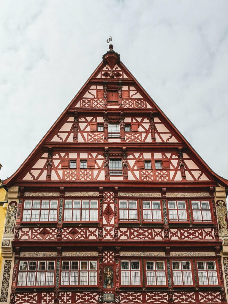 Das Bild zeigt die Fassade des Deutsches Hauses von Dinkelsbuehl mit kunstvollem roten Fachwerk