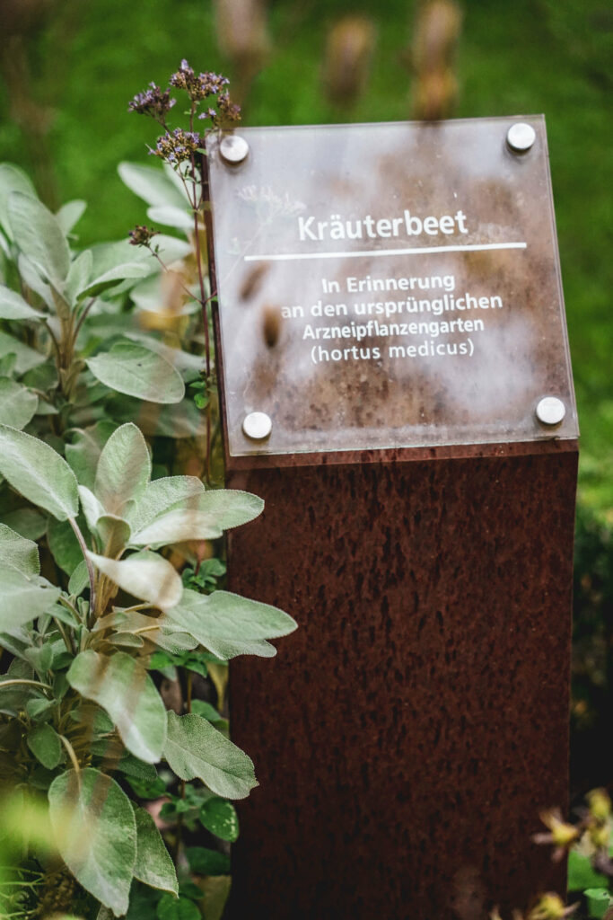Schild und Kraeuterbeet im Garten des Juliusspitals Wuerzburg