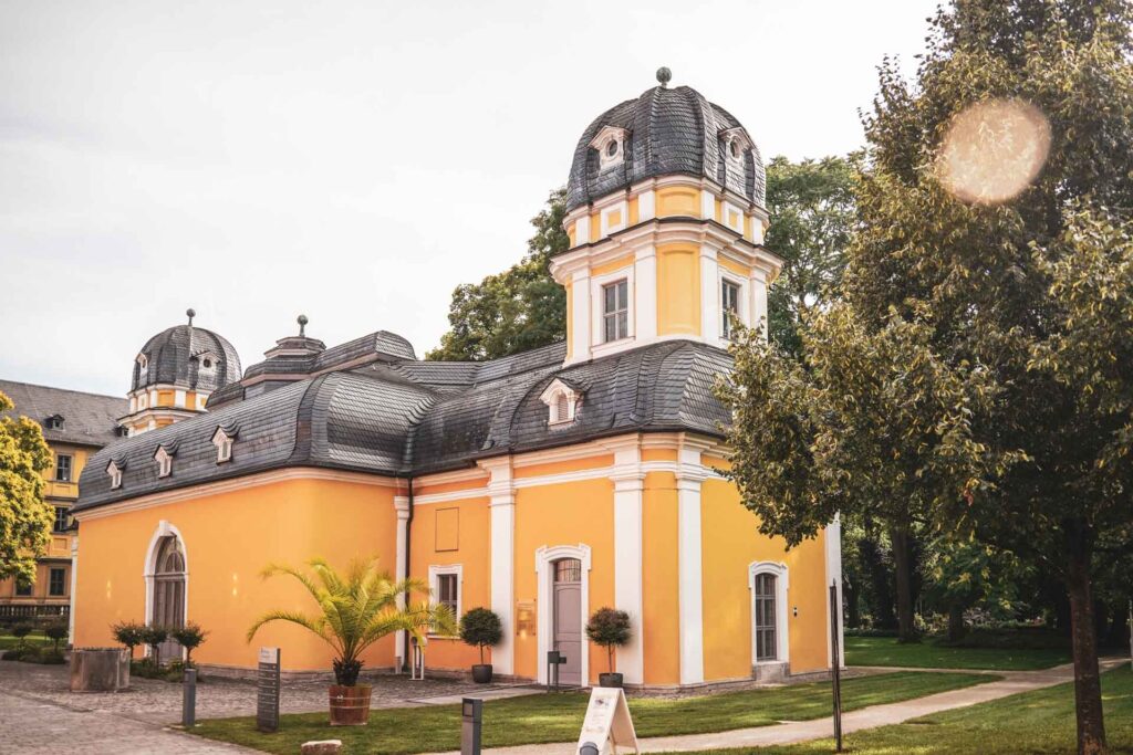 Foodtipps Würzburg: Frankenwein erleben: Das Weingut Juliusspital direkt in der Altstadt. Der historische Gartenpavillon in Gelb und Weiß im Sommer in der Nachmittagssonne