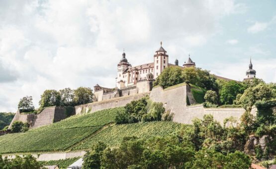 Reisetipps und Sehenswürdigkeiten Würzburg: Ausblick auf die Festung Marienberg und die Weinberge im Sommer