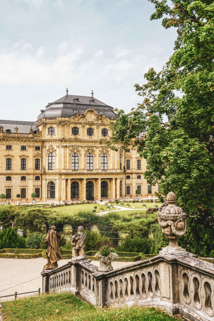 Reisetipps und Sehenswürdigkeiten Würzburg: Steintreppe im Hofgarten im Sommer mit Blick auf die Würzburger Residenz und die Barockfassade