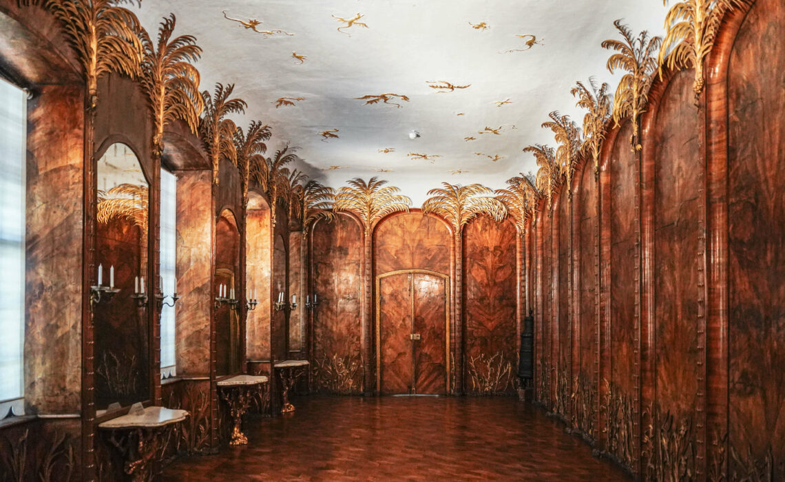 Das Palmenzimmer mit Nussholzvertäfelung und vergoldeten Palmbäumen im Neuen Schloss Bayreuth