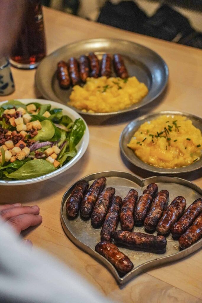 Foodguide Nürnberg – kleiner Bratwurstguide: Bratwürste essen im Gasthaus Zum gulden Stern in Nürnberg: Die Bratwürste werden auf traditionellen Zinntellern, rund und in Herzform, serviert, dazu gibt es Kartoffelsalat, Feldsalat und dunkles Bier der Brauerei Tucher