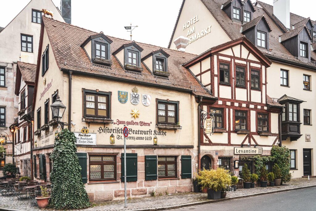Die Fassade der historischen Bratwurstküche Zum gulden Stern in Nürnberg mit Sandstein und Fachwerk