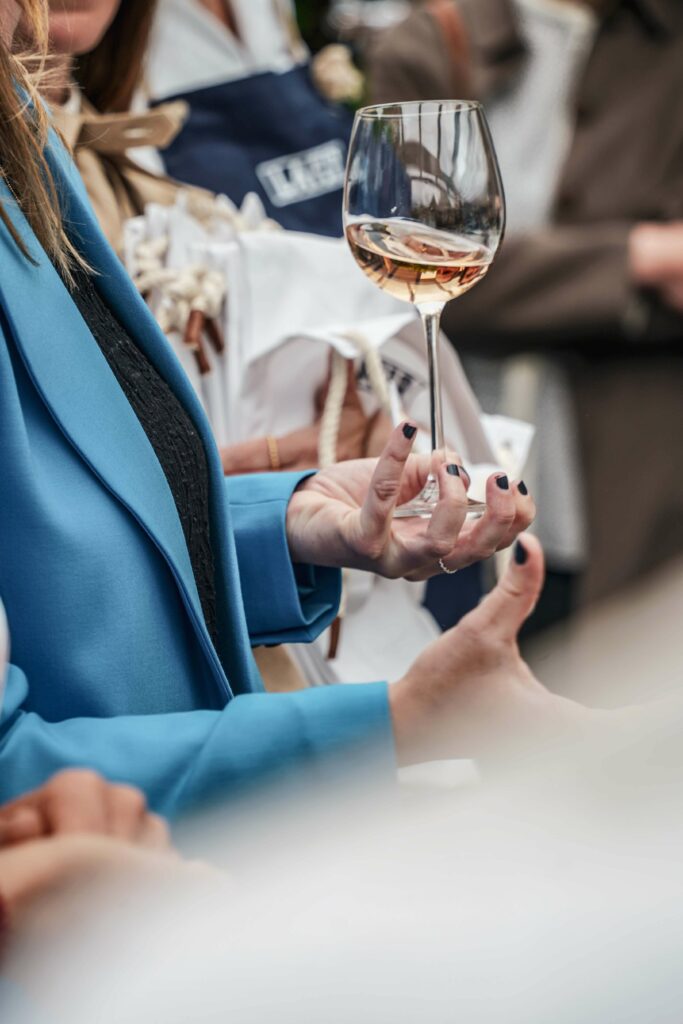 Elianne Vink, Export Area Manager bei Baron Philippe de Rothschild, hält den Aperitif, ein Glas Mouton Cadet Rosé Bio, während sie die Gäste zur Johann Lafer Experience in Guldental begrüßt