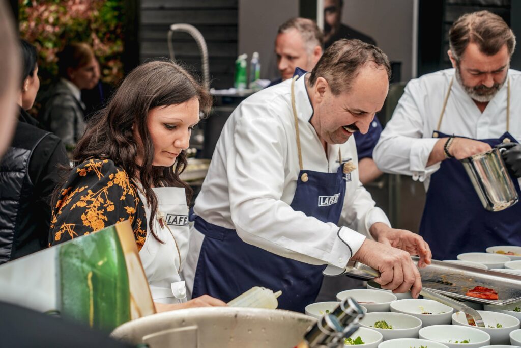 Seite an Seite mit dem Starkoch: Bloggerin Alexandra von Tables & Fables assistiert Johann Lafer bei der Zubereitung der Vorspeise seiner Outdoor-Küche in Guldental