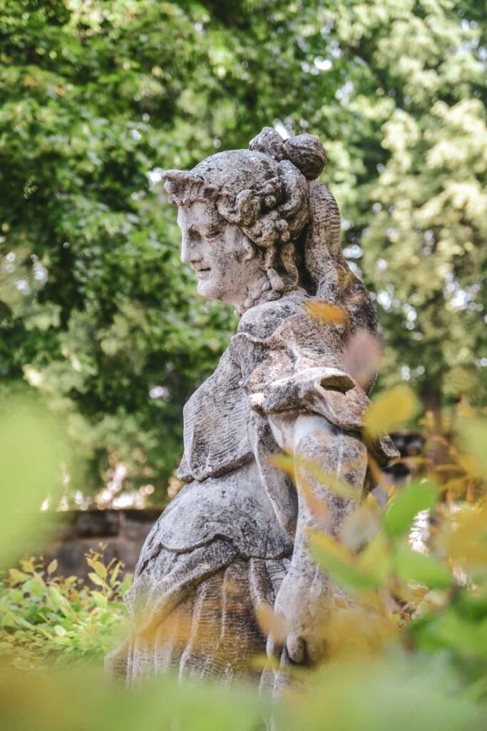 Skultpur aus Sandstein im Hofgarten des Neuen Schlosses in Bayreuth zwischen Laubengängen