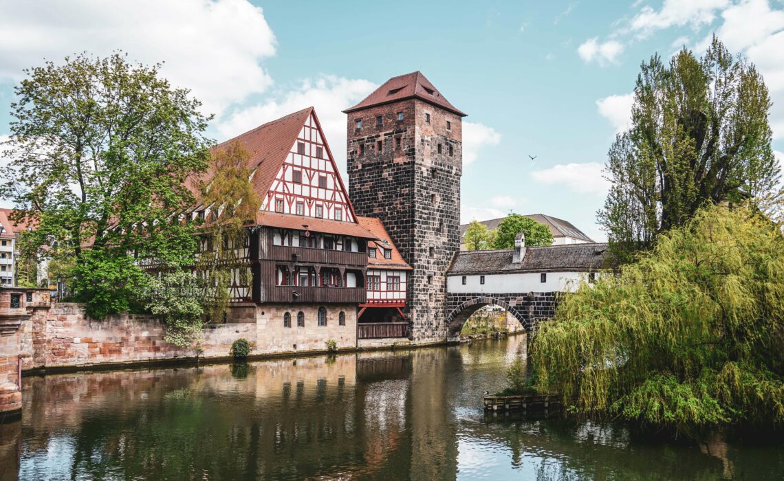 Beitragsbild Nürnberg: Fachwerkhaus mit Turm „Weinstadel” nahe der Maxbrücke in der nördlichen Altstadt am Fluss Pegnitz.