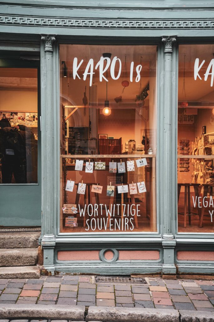 Das Schaufenster des Ladencafés KARO18 in Bamberg mit blau gestrichenem Holz und Papeterie im Schaufenster