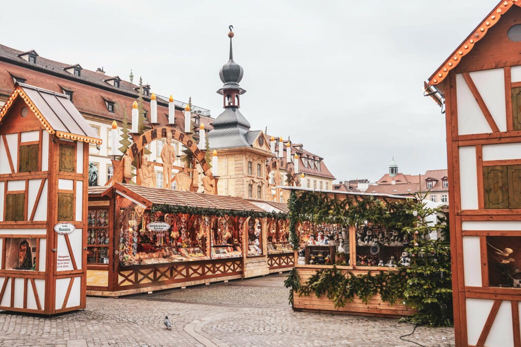 Weihnachtsmarkt in Bamberg: Geschmückte traditionelle Marktstände auf dem Maximiliansplatz mit Schwibbögen und einer Miniatur des Alten Rathauses