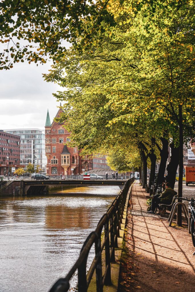 Fotospots in Hamburg im Herbst: Fußweg entlang des Holländischbrookfleets mit Herbstbäumen und Blick auf den St. Annenplatz in der Hamburger Speicherstadt