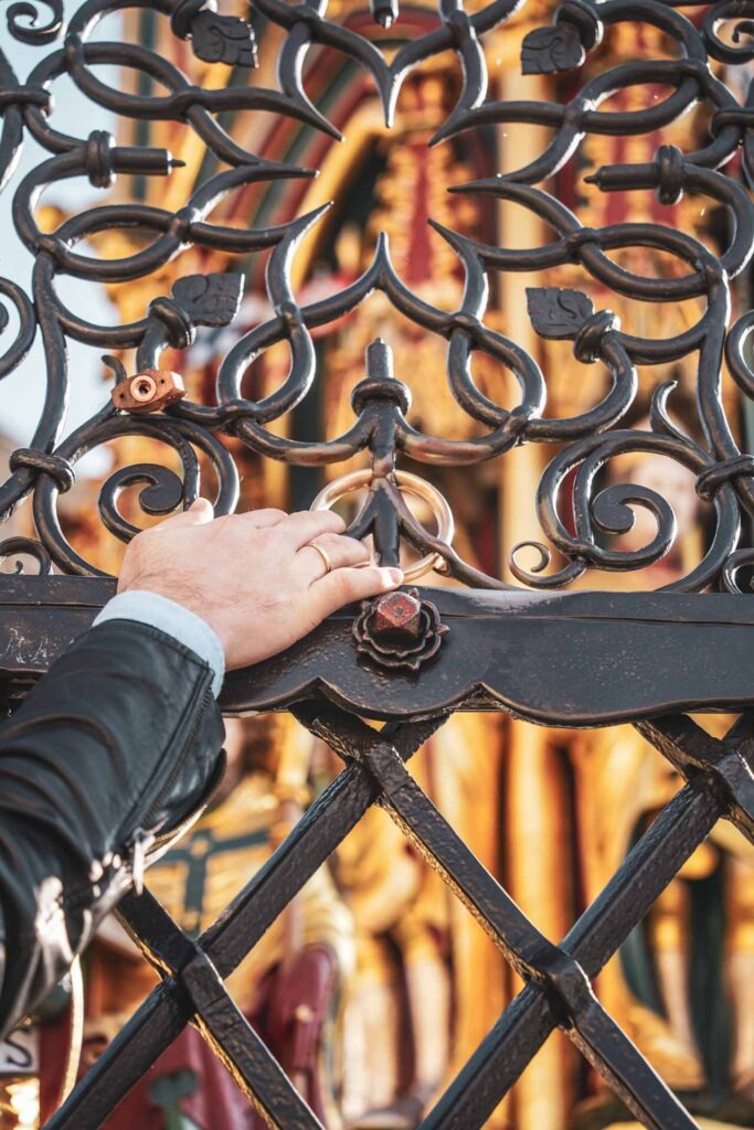 Sehenswürdigkeiten Nürnberg: Der berühmte goldene Ring am Schönen Brunnen am Nürnberger Hautpmarkt. Daran zu drehen, soll Glück bringen. Auf dem Bild ist die Hand von Blogger Floran von Tables & Fables am Ring zu sehen