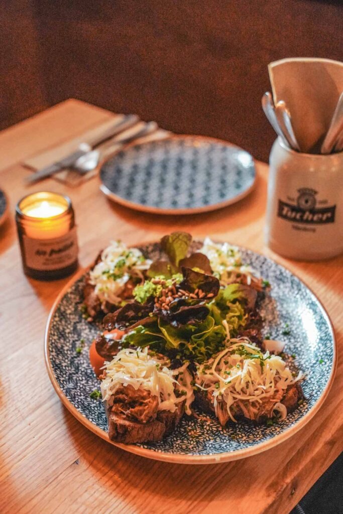 Eine Spezialität im Wirtshaus Tucher-Bräu: geröstetes Schwarzbrot mit gezupftem Schäufele in BBQ-Marinade und Krautsalat als Vorspeise