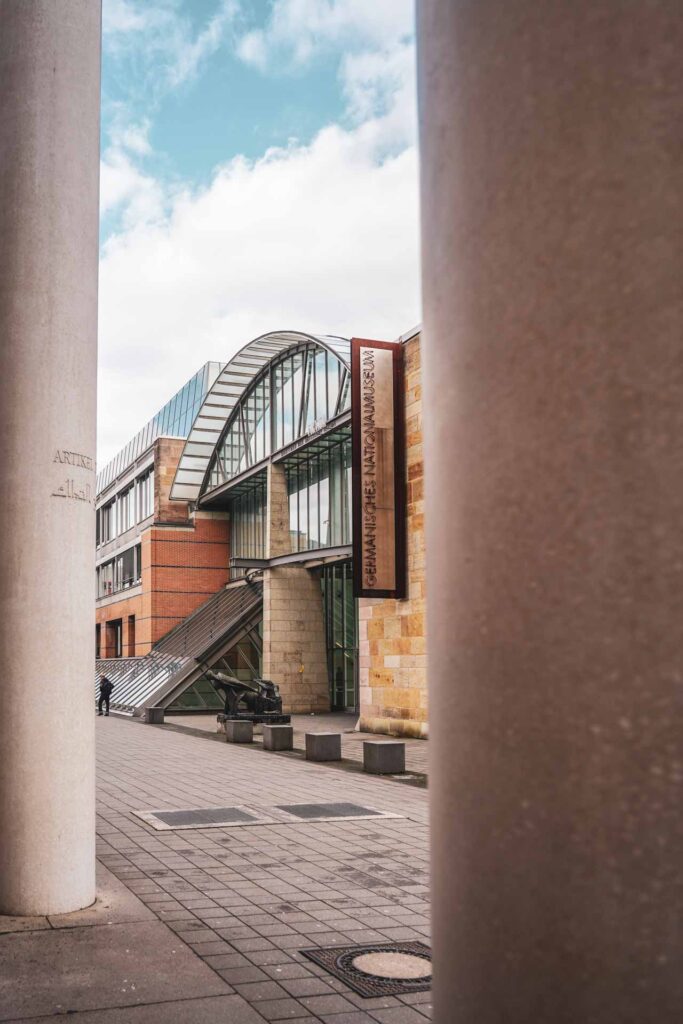 Sehenswürdigkeiten Nürnberg: Die Straße der Menschenrechte mit Blick auf das Germanische Nationalmuseum durch Säulen hindurch