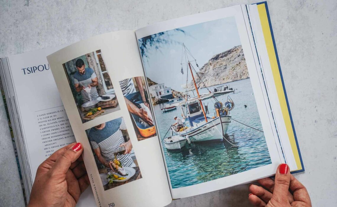 Die schönsten Kochbücher für den Sommer: Das Kochbuch Sonne und Meer auf dem Teller von Lazaros Kapageoroglou, erschienen im AT Verlag. Das Bild zeigt eine Doppelseite aus dem Buch. Links: Der Autor bereitet ein Fischgericht zu in mehreren Bildern und trägt ein Helllau gestreiftes Shirt. Rechts: Ein Fischerboot im Wasser in Weiß und Blau