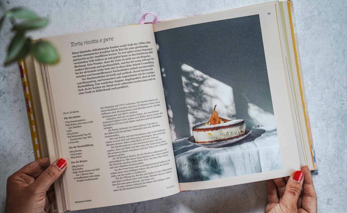 Die schönsten Kochbücher für den Sommer: Das Italien-Kochbuch La vita è dolce aus dem DK-Verlag. Das Bild zeigt eine Innenseite mit dem Rezept für Torta ricotta e pere, umgeben von Eukalyptus-Blättern
