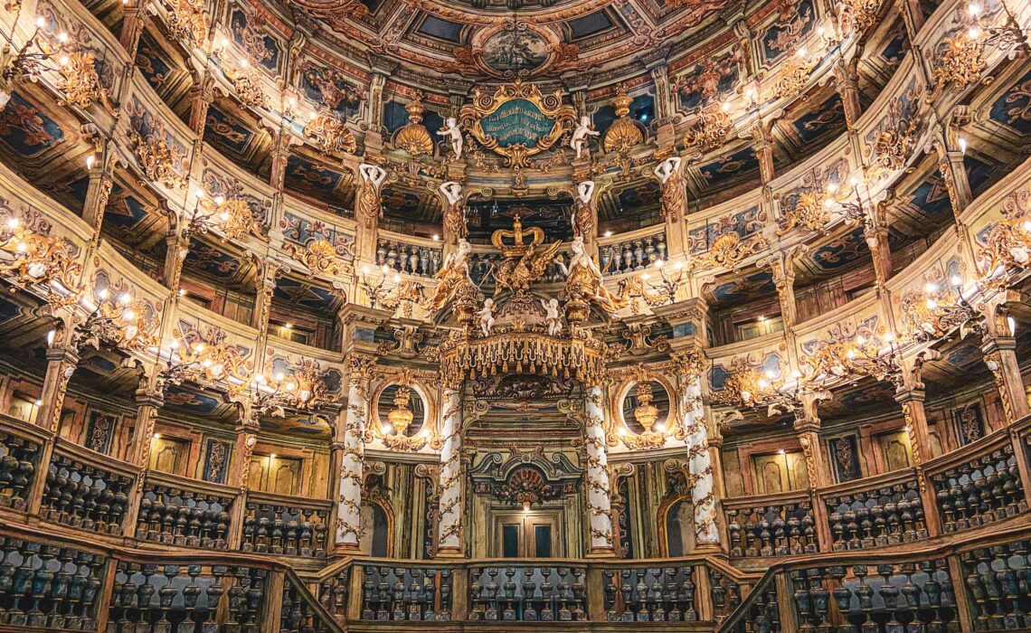 Sehenswürdigkeiten in Bayreuth: Das Markgräfliche Opernhaus zählt zu den schönsten Barocktheatern der Welt und ist seit 2012 UNESCO Weltkulturerbe. Auf dem Bild ist der beleuchtete Zuschauerraum mit der opulenten, goldverzierten Empore zu sehen