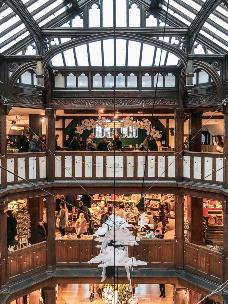 Das beeindruckende Treppenhaus des Luxuskaufhauses Liberty in London, das mit viel Holz errichtet wurde und aussieht, als wäre man in einem Schiffsbau, weihnachtlich dekoriert