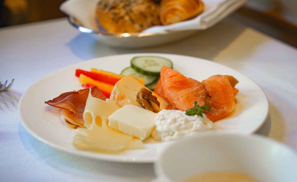 250922-Celle-Althoff-Hotel-Fuerstenhof-Fruehstueck-Teller-Kaese-Schinken-Lachs-Kaffee-Broetchen-1920x1280
