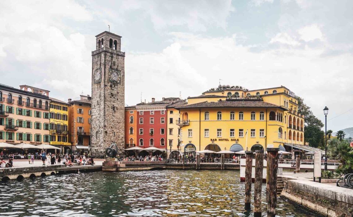 Die schönsten Orte am Gardasee: Die Uferpromenade von Riva del Garda mit den bunten Häusern der Altstadt und dem imposanten Torre Apponale