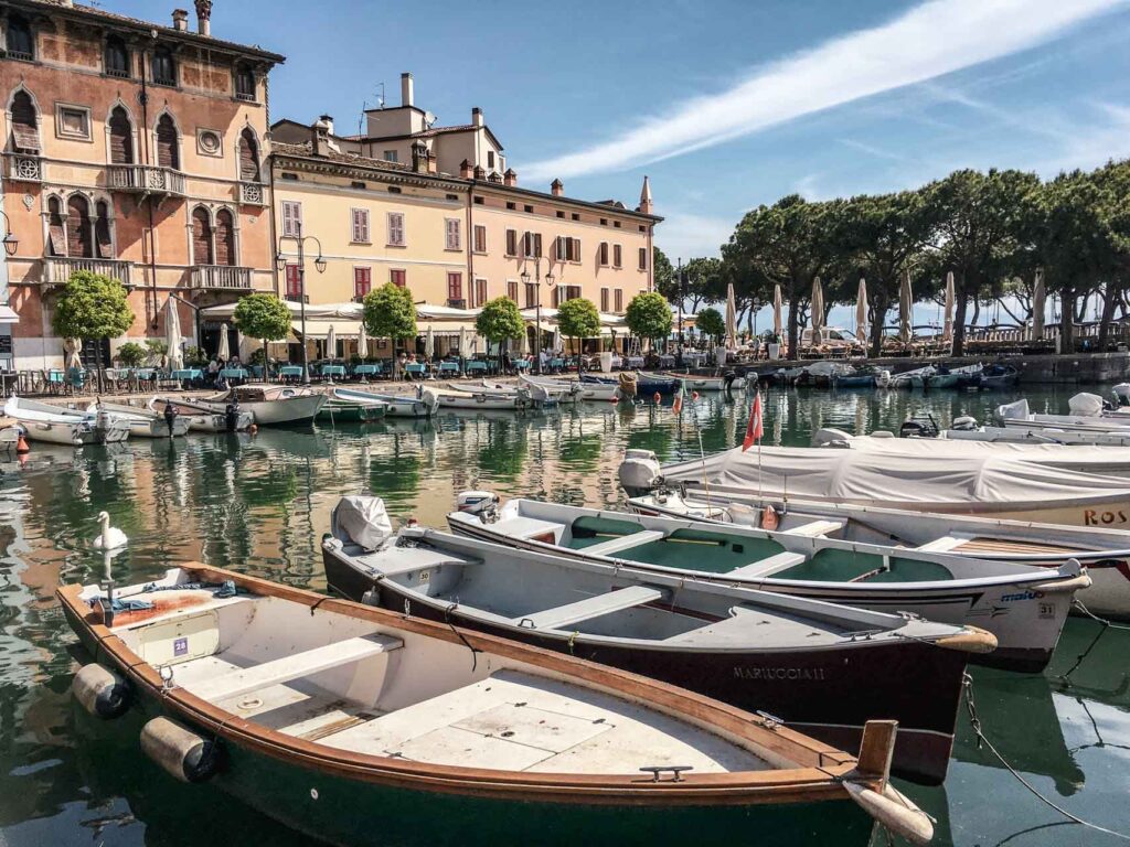 Die schönsten Orte am Gardasee: Blcik auf den Porto Vecchio in Desenzano del Garda mit bunten Fischerbooten