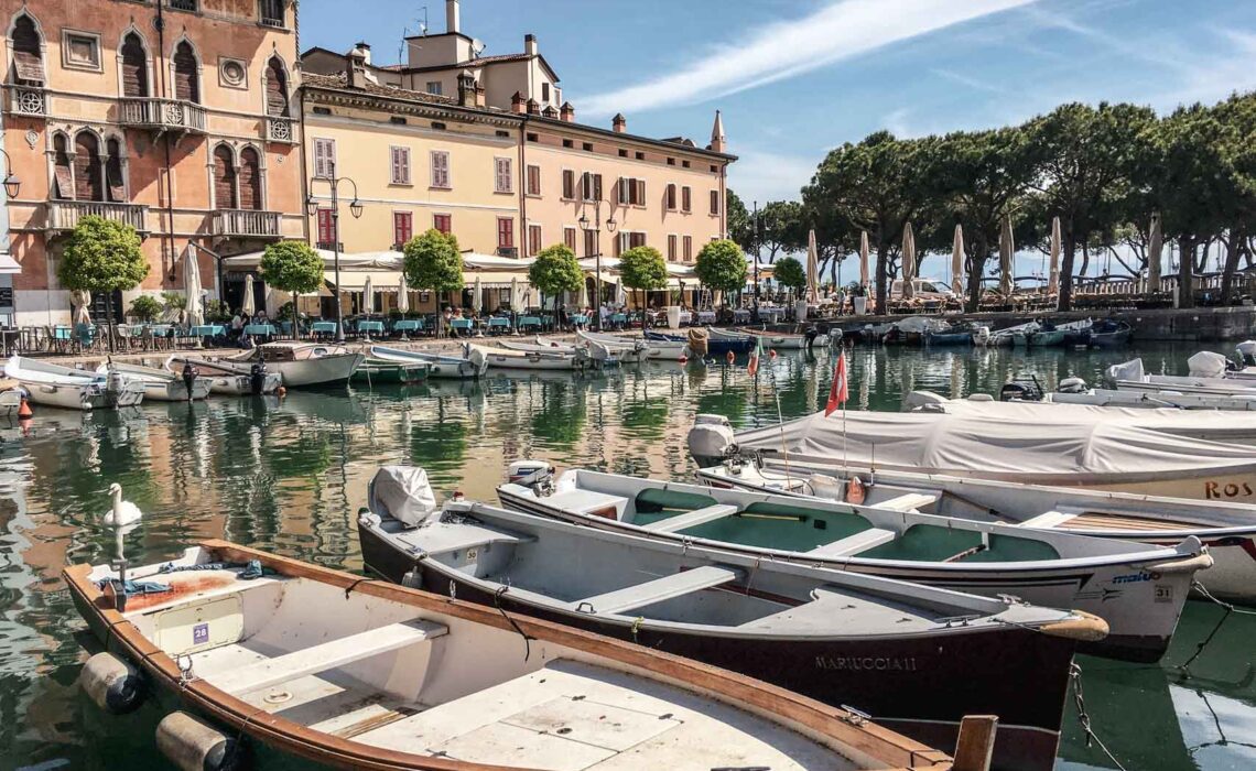 Die schönsten Orte am Gardasee: Blcik auf den Porto Vecchio in Desenzano del Garda mit bunten Fischerbooten