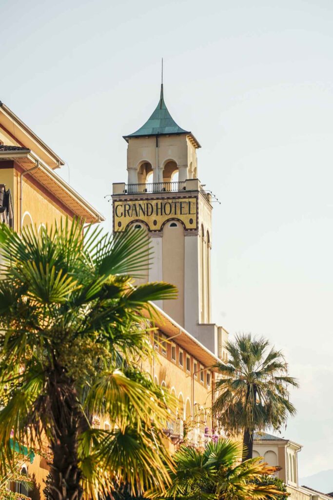 Die schönsten Orte am Gardasee: Turm des Grand Hotels Gardone Riviera mit Palmen