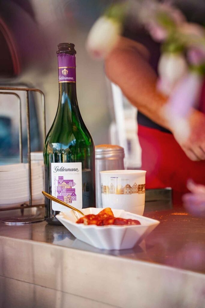 Geldermann x KPM –Launch der Bayreuther Festspiel-Cuvée zu Richard Wagners Die Meistersinger von Nürnberg 2025: Sekt und Currywurst von Curry 36 im Foodtruck beim Sektempfang im Innenhof der KPM Berlin