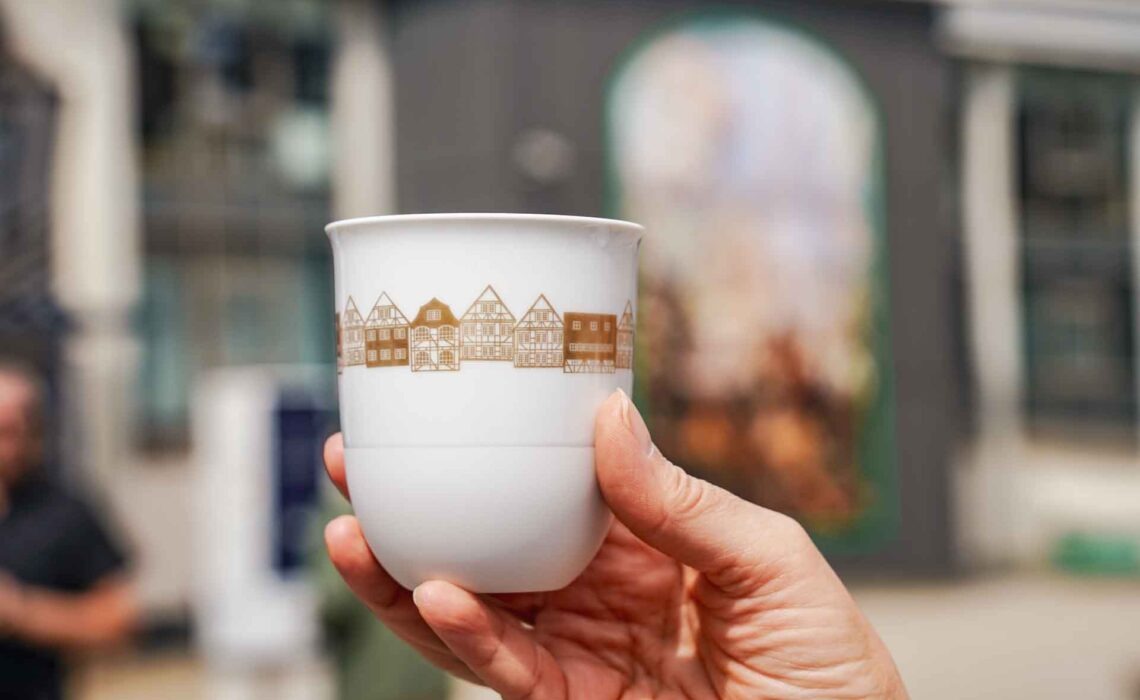 Geldermann x KPM –Launch der Bayreuther Festspiel-Cuvée zu Richard Wagners Die Meistersinger von Nürnberg 2025: Der KPM LAB-Porzellanbecher mit goldenen Illustrationen einer Fachwerkhäuser-Reihe