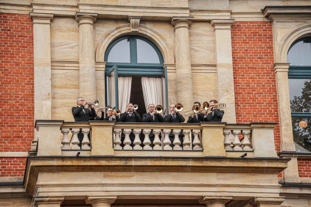 Mit Geldermann bei den Bayreuther Festspielen 2025: Die berühmten Pausenmusiker auf dem Balkon des Bayreuther Festspielhauses kündigen traditionell den nächsten Akt an