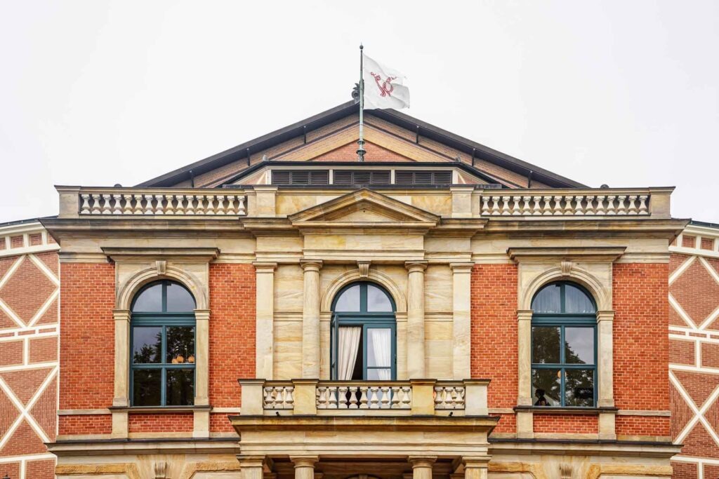 Mit Geldermann bei den Bayreuther Festspielen 2025: Das Festspielhaus in Bayreuth mit der gehissten weißen Flagge mit dem großen W in Rot über dem Balkon