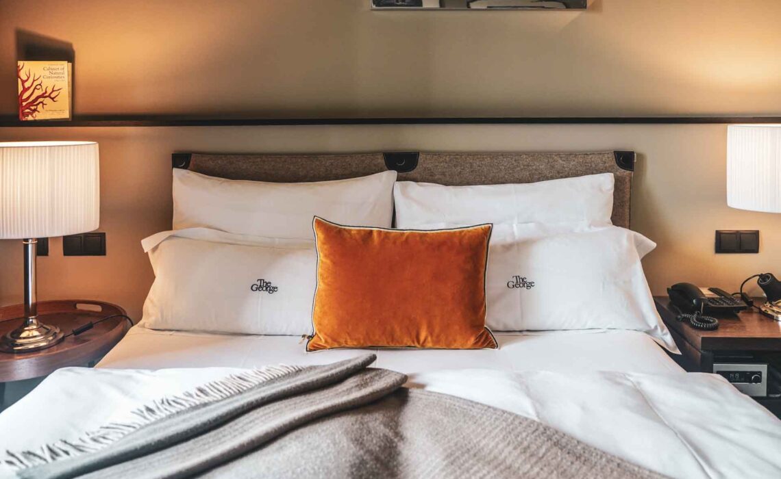 Hoteltipps Hamburg: Gemütliche Hotelbetten im stylisch-urbanen Zimmer mit Alster-Blick im The George Hotel in St. Georg