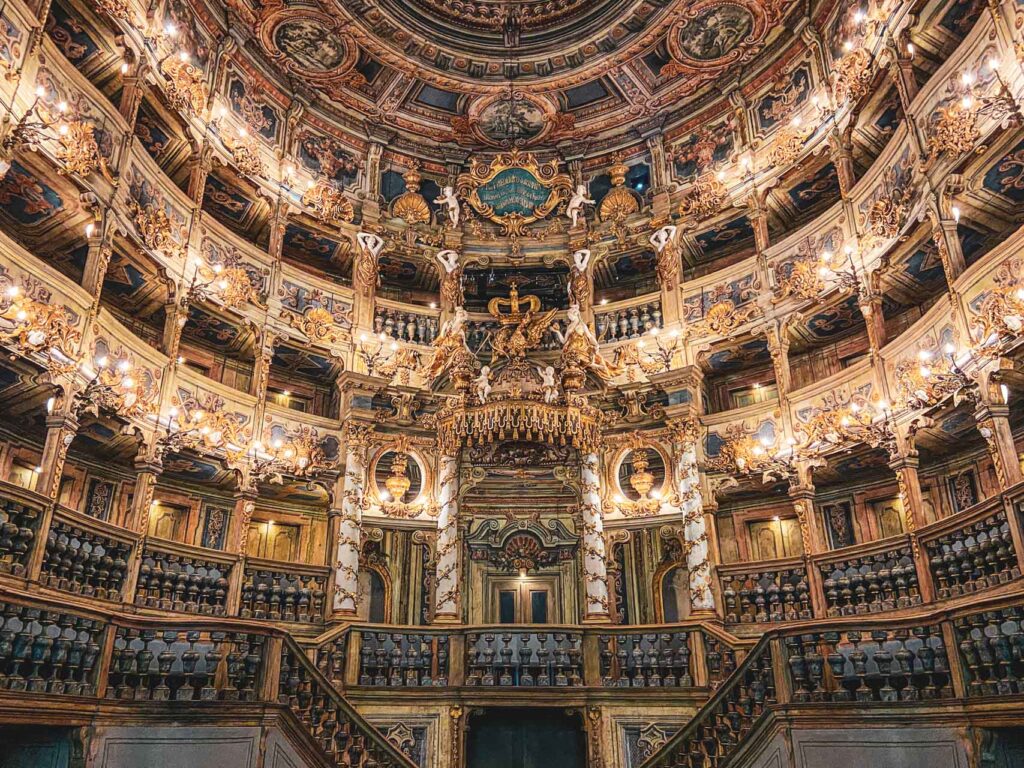 Sehenswürdigkeiten in Bayreuth: Das Markgräfliche Opernhaus zählt zu den schönsten Barocktheatern der Welt und ist seit 2012 UNESCO Weltkulturerbe. Auf dem Bild ist der beleuchtete Zuschauerraum mit der opulenten, goldverzierten Empore zu sehen