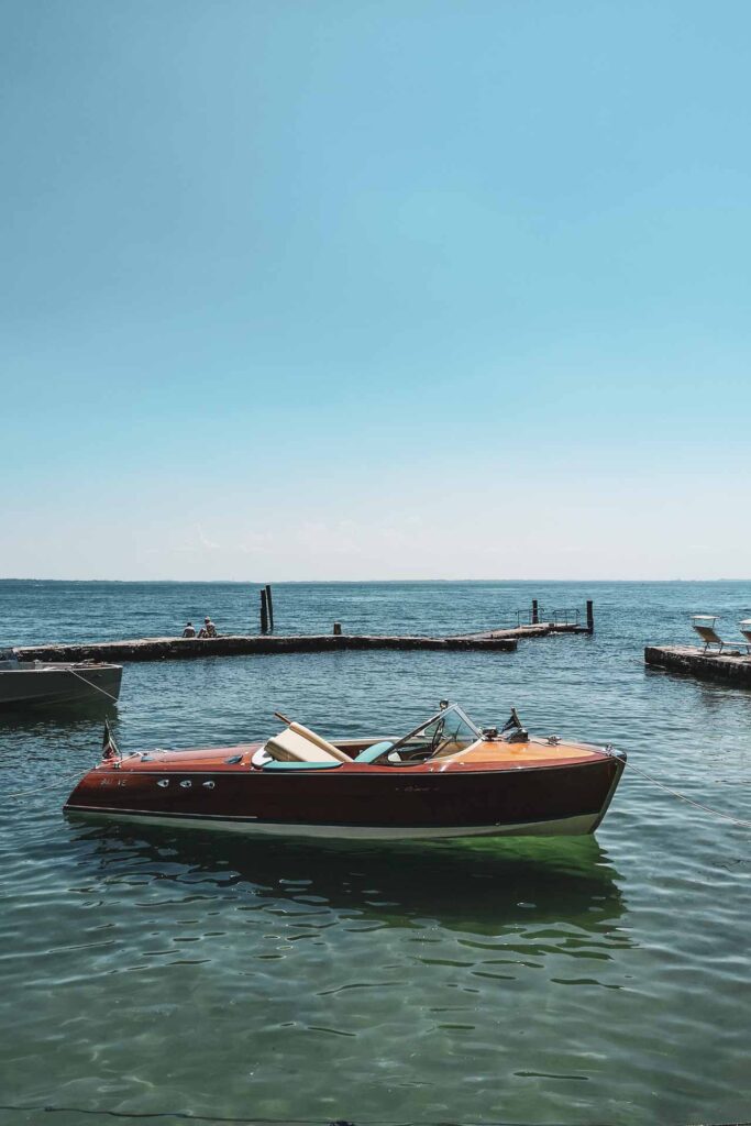 Die schönsten Orte am Gardasee: Riva-Boot an der Anlegestelle der Taverne der Locanda San Vigilio an der Punta San Vigilio am Ostufer des Gardasees